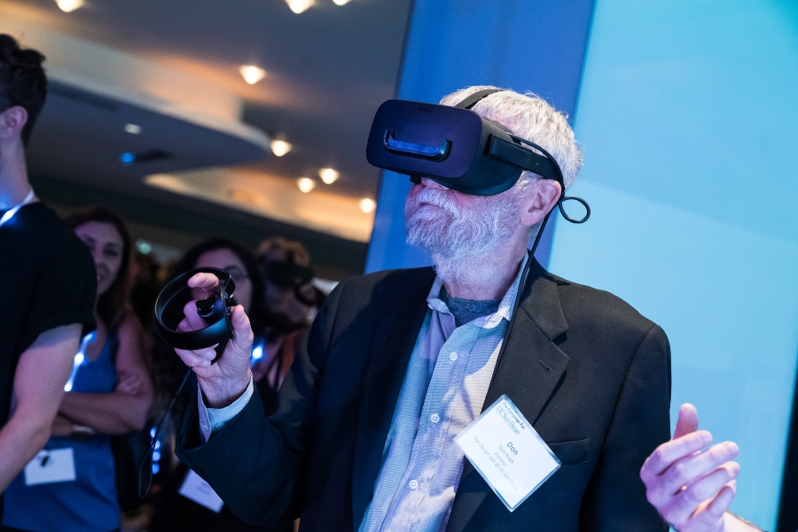 Don Norman at the Chancellor’s Campaign interacts with an exhibit, equipped with a VR headset and controller.