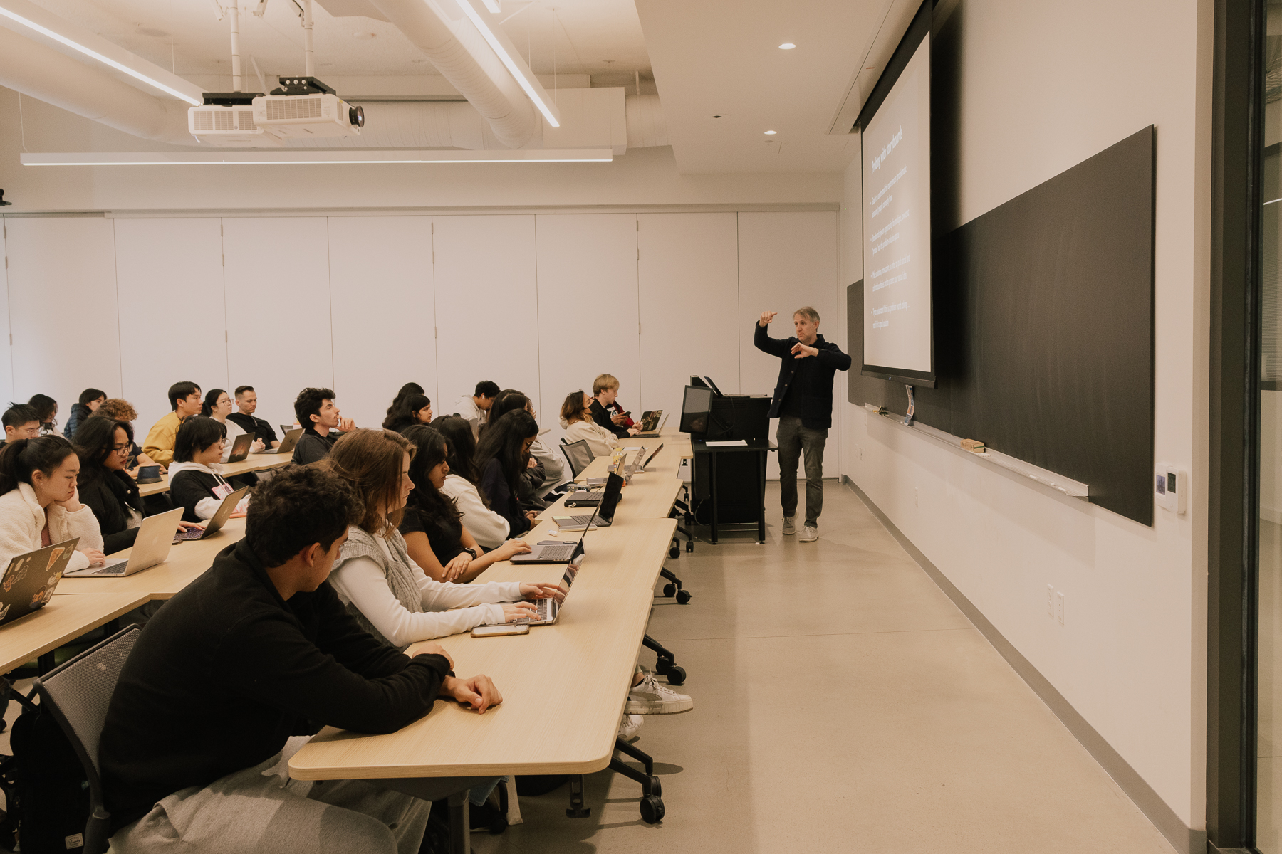 Steven Dow teaching a classroom of undergraduate students